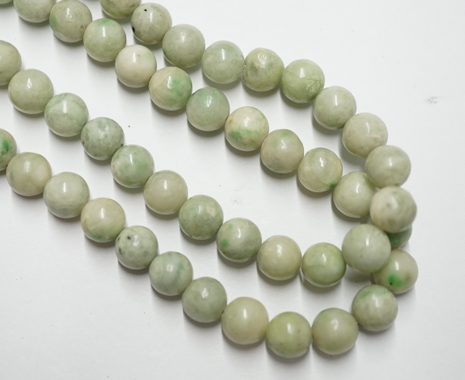 A double strand jade bead choker necklace, with cabochon jade set yellow metal clasp, 38cm. Condition - poor to fair